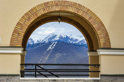 Scenic view of snowcapped mountains against sky seen through window