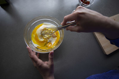 Overhead view of someone whisking milk into eggs in a bowl.