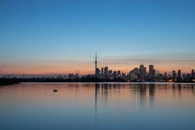 Reflection of buildings in lake during sunset