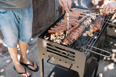 Low section of man standing on barbecue grill