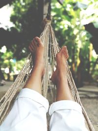 Low section of woman relaxing on hammock