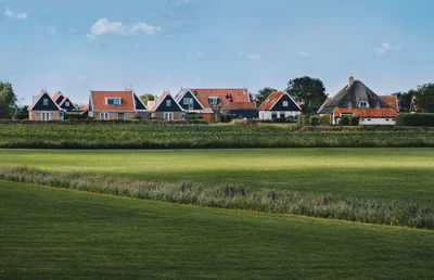 Houses on field against sky