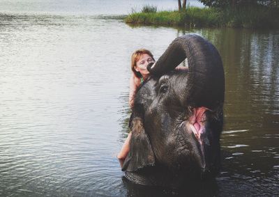 Woman with dog swimming in lake