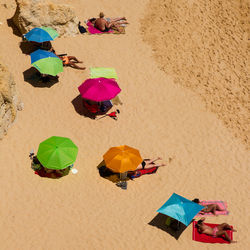 High angle view of multi colored umbrellas on sand