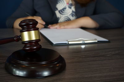 Midsection of person holding book on table