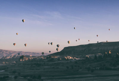 Hot air balloons flying over landscape