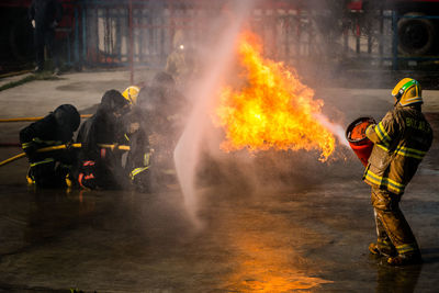 People standing by fire on street in city