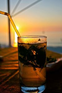 Close-up of cocktail against sky during sunset