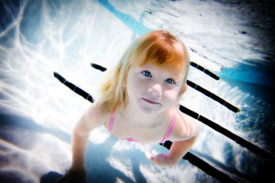 Portrait of cute girl swimming in pool