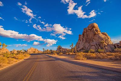 Road amidst rocks against sky