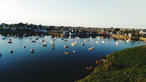 High angle view of sea by city against clear sky