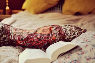 Close-up of book with pillow on bed