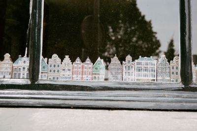 Building by trees seen through glass window