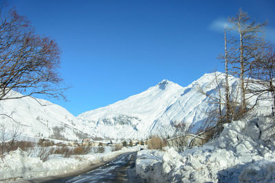 Scenic view of snowcapped mountains against clear blue sky