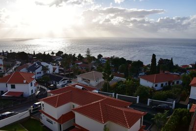 High angle view of townscape by sea against sky