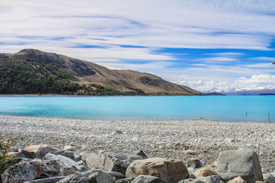 Scenic view of sea and mountains against sky