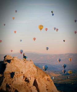 Hot air balloons flying over mountain