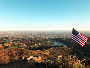 Scenic view of flag and buildings against clear blue sky