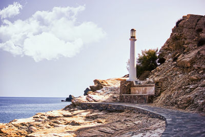 Scenic view of rocks by sea against sky