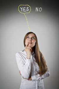 Young woman looking up against white background