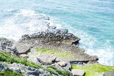 High angle view of rocks on sea shore