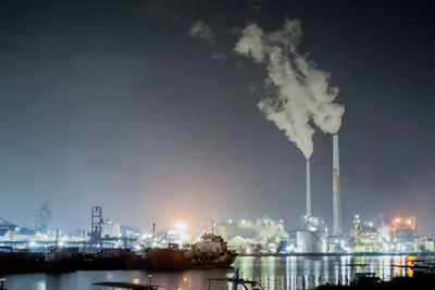 Smoke emitting from factory against sky at night