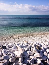 Pebbles on beach against sky