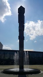 Low angle view of fountain against buildings in city