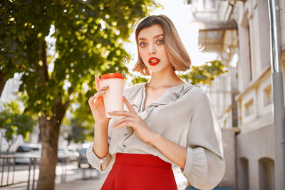 Portrait of a beautiful young woman drinking drink