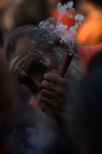 Old man smoking. smoking chillum. sadhu smoking in india. kumbh mela.