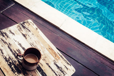 High angle view of coffee on cutting board over poolside