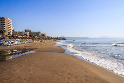 Scenic view of beach and buildings against sky