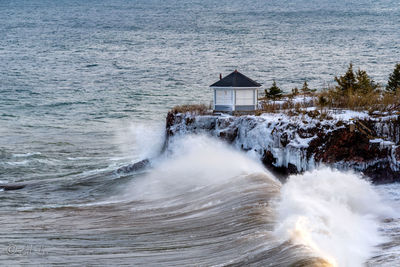 Water flowing on beach by house and sea