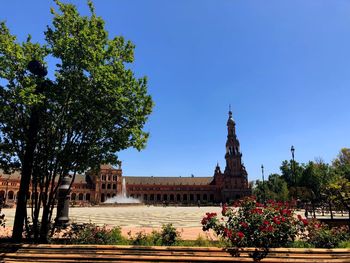 Trees outside temple against clear blue sky