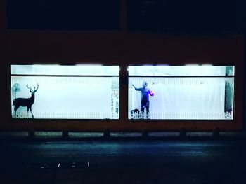 Rear view of people standing on glass window