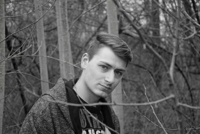 Portrait of young man standing in forest