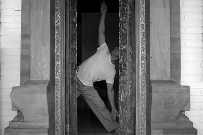 Man doing yoga seen through doorway