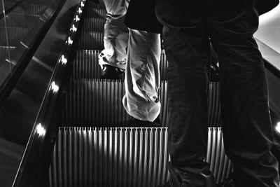 Low section of people standing on escalator