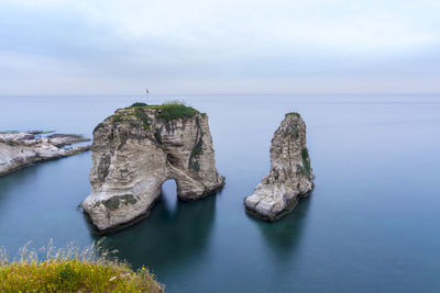 Rocks in sea against sky