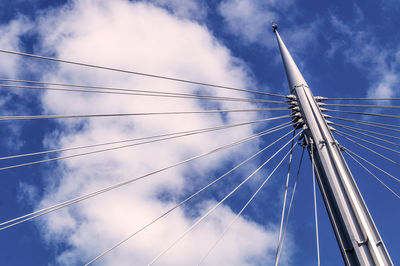 Low angle view of mast of sailboat against cloudy sky