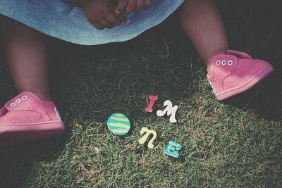 Close-up low section of baby sitting on grass