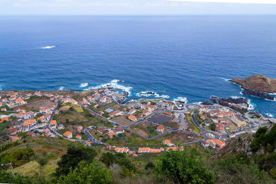 High angle view of town by sea against sky