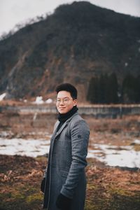 Portrait of young man standing on field