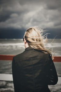 Rear view of woman standing against sky