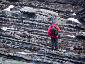 Rear view of man standing on rock