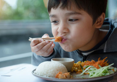 Portrait of boy eating food