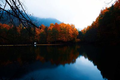 Reflection of trees in calm lake during autumn