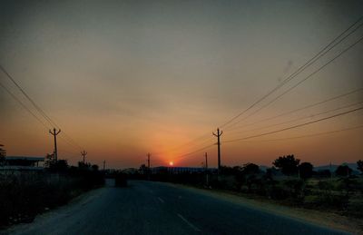 Silhouette road against sky during sunset