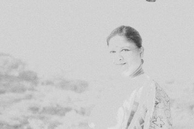 Portrait of a smiling young woman against sky