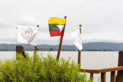 The burmese flag in the wind against mountains